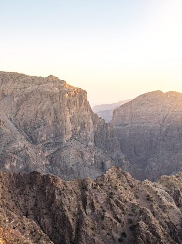 Rugged rocky mountains under a bright sky with warm low sun